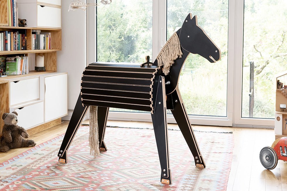 Holzpferd in aufgeräumtem Wohnzimmer für Kinder