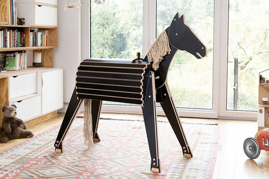 Holzpferd in aufgeräumtem Wohnzimmer für Kinder